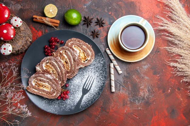 Vue de dessus délicieux rouleaux de biscuits avec du thé sur fond sombre