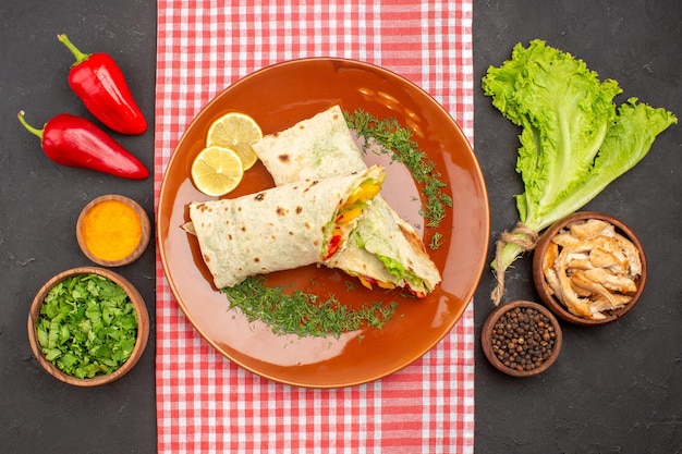 Vue De Dessus D'un Délicieux Sandwich à La Salade De Shaurma En Tranches Avec Des Légumes Verts Et De La Salade Dans L'obscurité