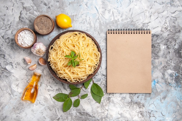 Vue de dessus de délicieux spaghettis à l'intérieur de la plaque sur des pâtes de plat de repas de table blanche