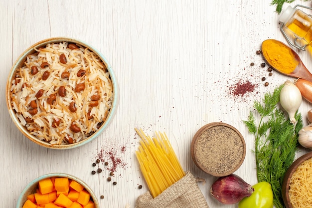 Vue de dessus de délicieux vermicelles cuits avec des haricots sur une table blanche