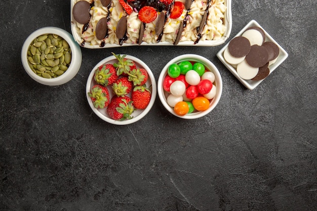 Vue de dessus dessert délicieux avec des biscuits et des bonbons sur fond sombre biscuit aux noix biscuit aux fruits sucrés au sucre