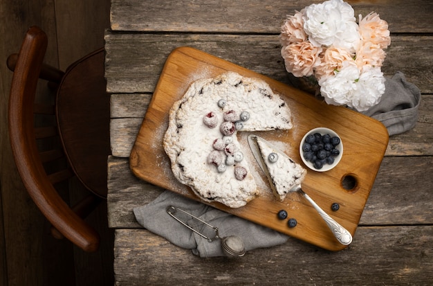 Photo gratuite vue de dessus dessert et fleurs sur table