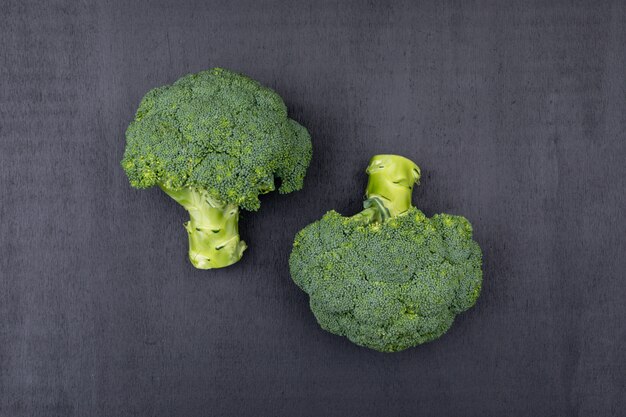 Vue de dessus deux bouquets de brocoli sur une surface noire