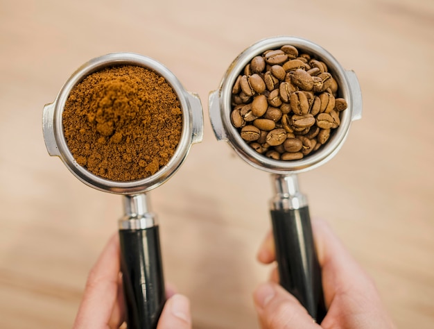 Vue de dessus de deux tasses de machine à café tenues par le barista