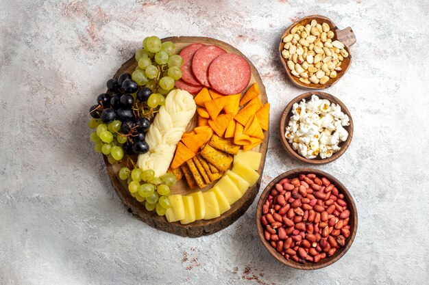 Vue de dessus différentes collations de raisins frais cips de fromage avec des noix sur l'espace blanc