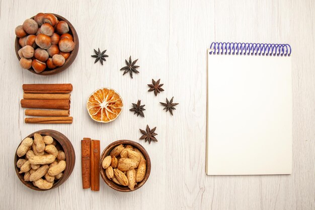 Vue de dessus différentes noix à la cannelle sur le bureau blanc casse-croûte noix noisette noisette