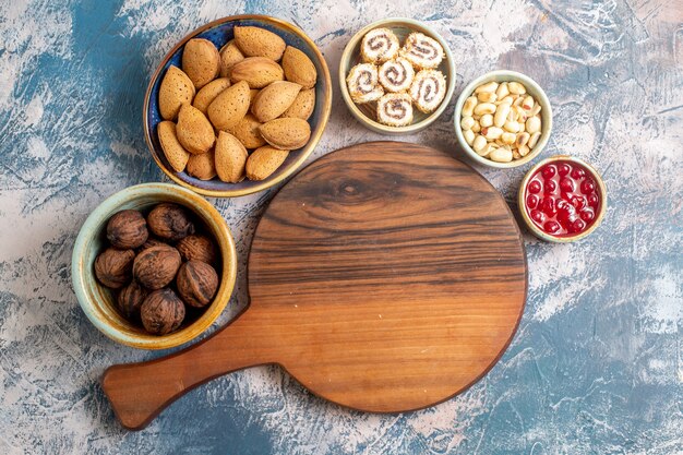 Vue de dessus de différentes noix avec confitures et confiture sur une surface légère