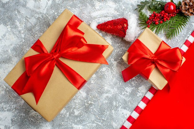 Vue de dessus différentes tailles cadeaux de noël petit bonnet de noel sur tableau blanc gris