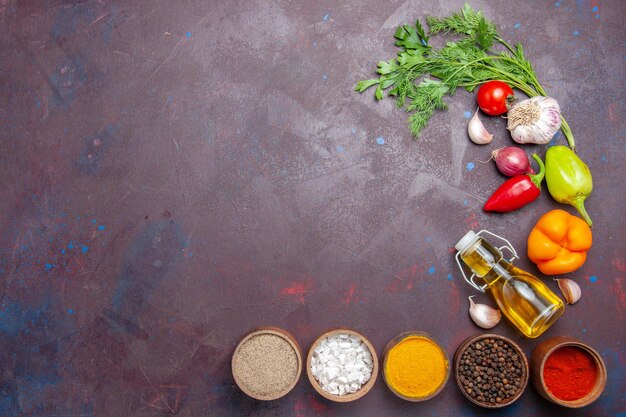 Photo gratuite vue de dessus différents assaisonnements avec des légumes sur fond sombre régime de santé de salade de repas