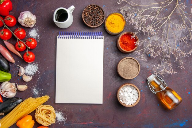 Vue de dessus différents assaisonnements avec des légumes sur le fond sombre salade de piment épicé repas santé