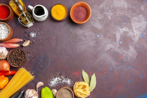 Vue de dessus différents assaisonnements avec des légumes frais sur le fond sombre salade de nourriture épicée de poivre santé