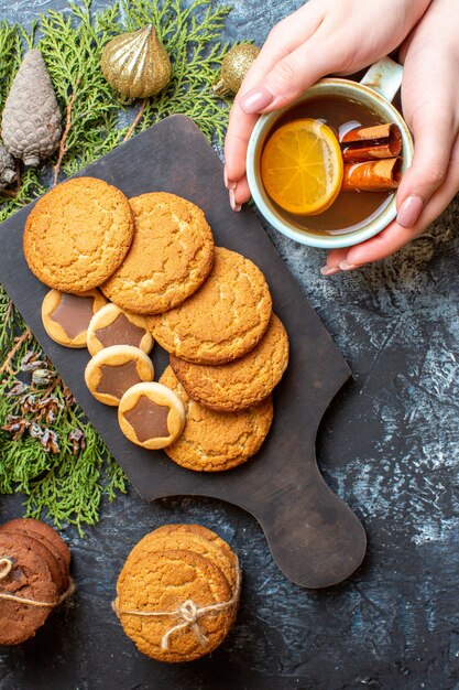 Vue de dessus différents biscuits délicieux avec une tasse de thé sur une table lumineuse