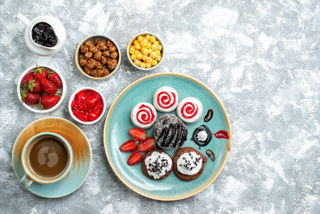 Vue de dessus différents bonbons avec café noix et biscuits sur espace blanc