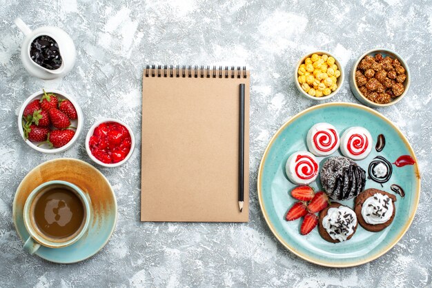 Vue de dessus différents bonbons avec café noix et biscuits sur espace blanc