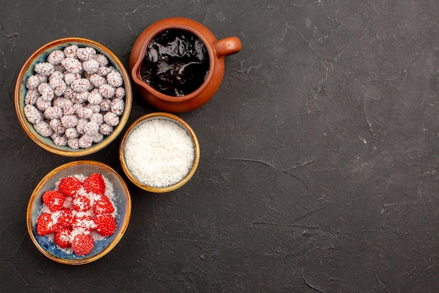 Vue de dessus différents bonbons avec du sirop de chocolat sur un biscuit au thé aux bonbons de couleur sombre