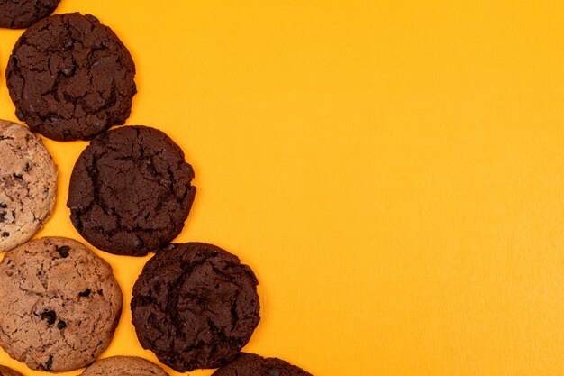 Vue de dessus différents cookies sur une surface jaune