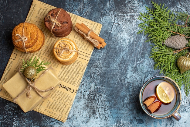 Vue de dessus différents délicieux biscuits avec présent et thé sur fond clair