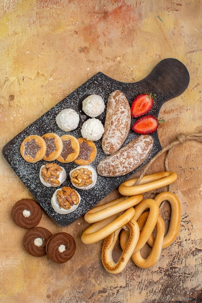 Photo gratuite vue de dessus différents gâteaux et biscuits bonbons sur un bureau en bois