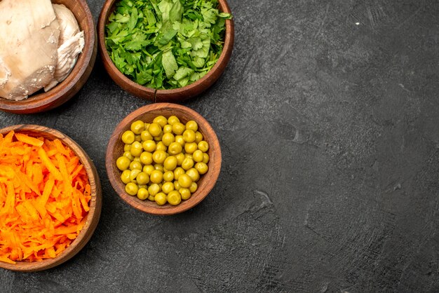 Vue de dessus différents ingrédients de la salade avec du poulet sur une table grise repas santé régime