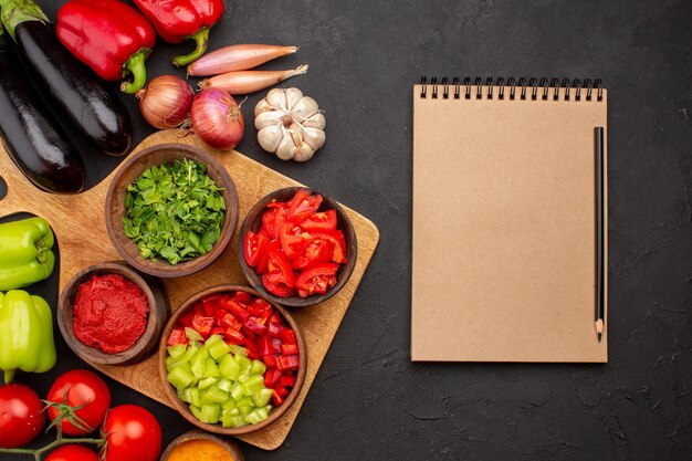 Vue de dessus différents légumes frais et mûrs sur le fond gris salade repas santé mûr