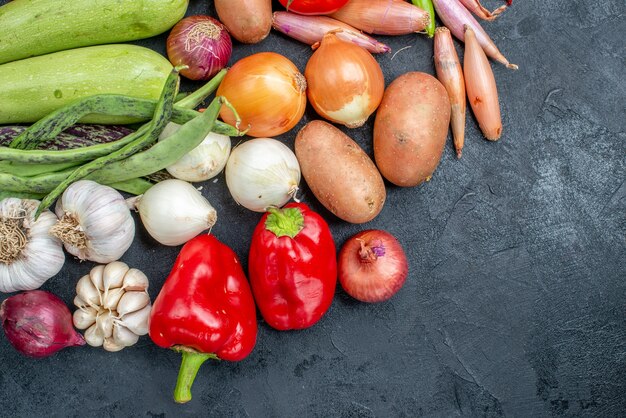 Vue de dessus différents légumes frais sur table sombre couleur fraîche de légumes mûrs