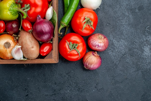 Vue de dessus différents légumes frais sur table sombre salade de légumes frais