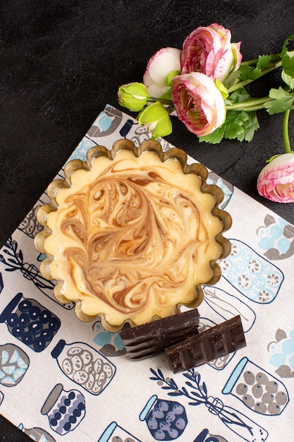 Une vue de dessus distancié délicieux gâteau au café sucré délicieux gâteau de boulangerie sucré sucré sur le bureau sombre