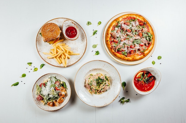 Vue de dessus des divers aliments frais délicieux et savoureux sur une surface blanche en bois