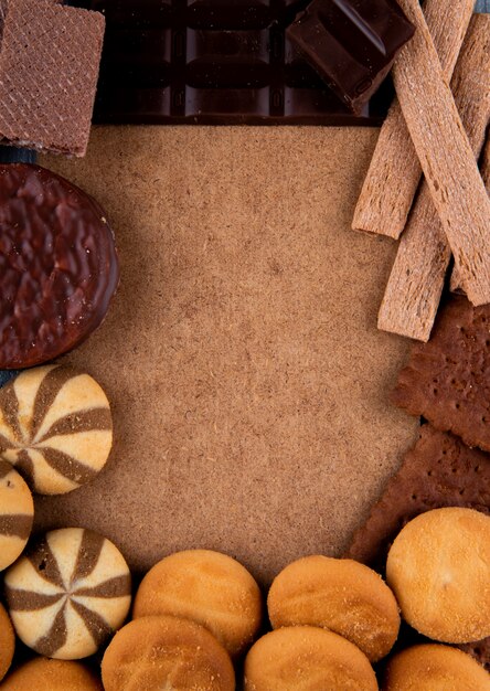 Vue de dessus de divers biscuits sucrés avec une feuille de carton au milieu avec copie espace