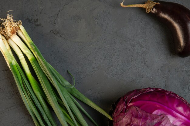 Vue de dessus de divers légumes frais aubergine chou rouge et oignon vert avec copie espace sur dark j