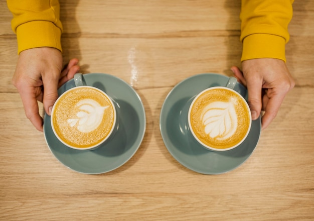 Photo gratuite vue de dessus du barista avec deux tasses de café