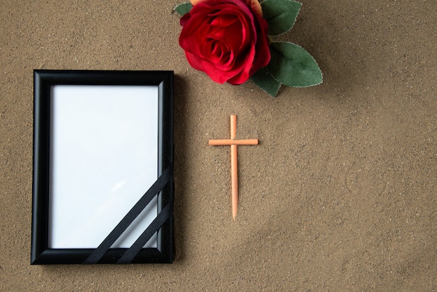 Vue de dessus du bâton croix avec fleur rouge et cadre photo sur le sable mort funéraire palestine