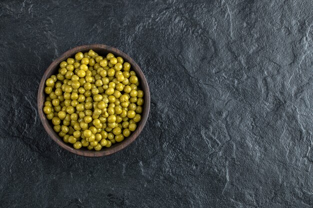 Vue de dessus du bol plein de petits pois marinés verts