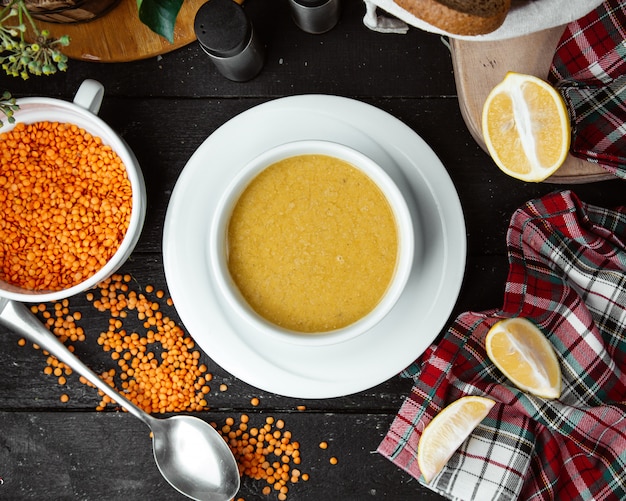 Vue de dessus du bol de soupe aux lentilles servi avec du citron