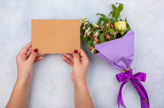 Vue de dessus du bouquet violet de rose avec des feuilles sur une surface blanche