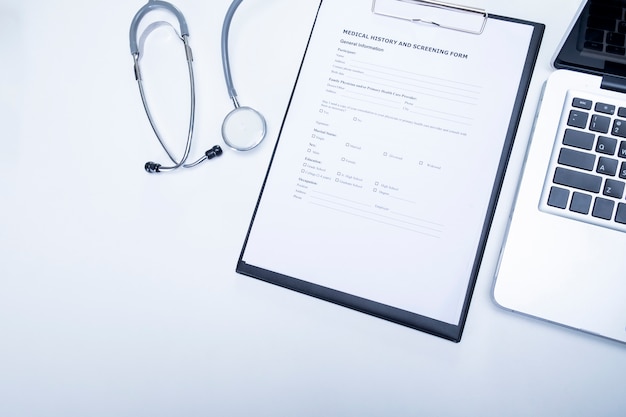 La vue de dessus du bureau de médecin avec stéthoscope, presse-papiers avec fiche médicale et ordinateur portable