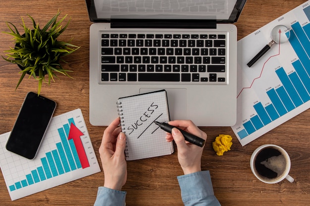 Vue de dessus du bureau avec ordinateur portable et courbe de croissance