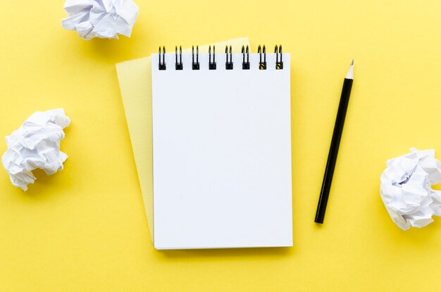 Vue de dessus du bureau avec ordinateur portable et papier froissé