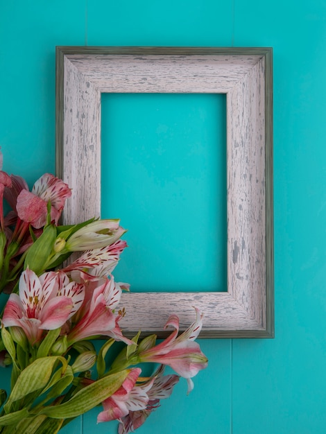 Vue de dessus du cadre gris avec des lys roses sur une surface bleue