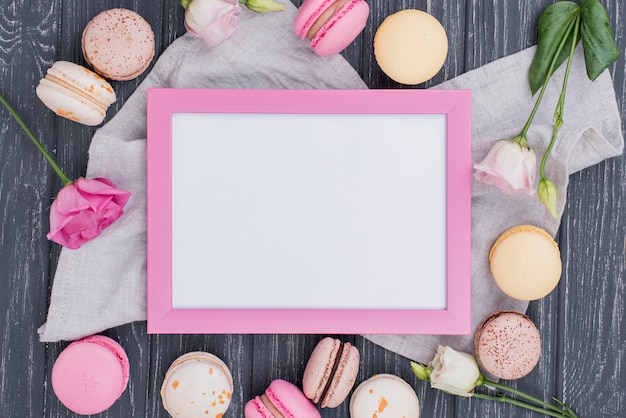 Vue de dessus du cadre avec des macarons et des roses