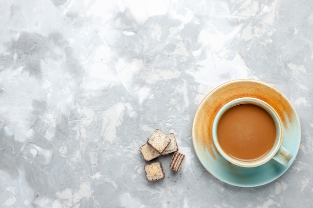 Vue de dessus du café au lait avec des gaufres sur le bureau léger