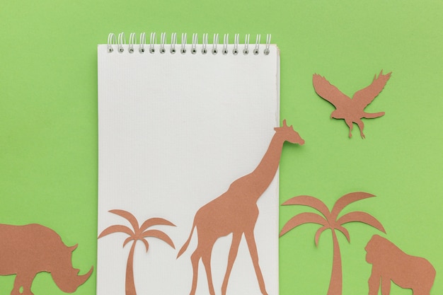 Vue de dessus du cahier avec des animaux en papier pour la journée des animaux