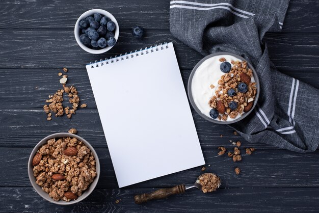 Vue de dessus du cahier avec céréales de petit déjeuner et bleuets