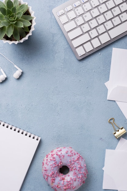 Photo gratuite vue de dessus du cahier et du beignet sur le bureau