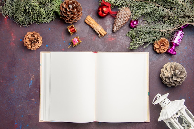 Vue de dessus du cahier ouvert avec arbre de noël et cônes sur fond noir