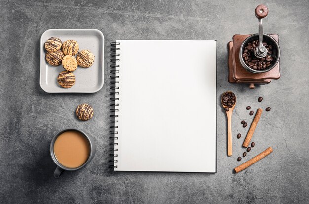 Vue de dessus du cahier avec tasse à café et moulin