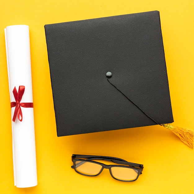 Vue de dessus du cap académique avec diplôme et lunettes