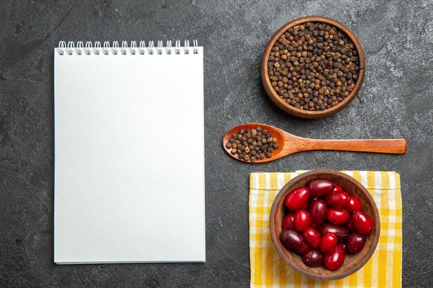 Vue de dessus du cornouiller rouge frais avec du poivre sur la surface grise