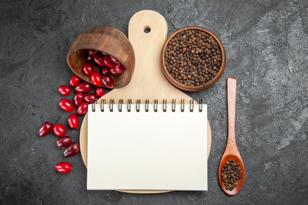 Vue de dessus du cornouiller rouge frais avec du poivre sur la surface grise