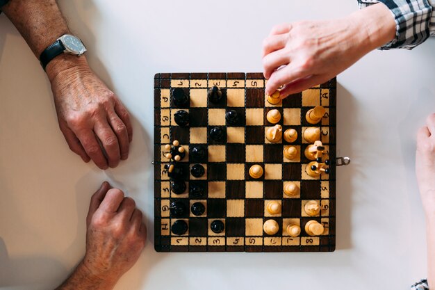 Vue de dessus du couple âgé jouant aux échecs dans la maison de retraite